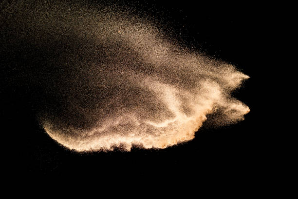 Dry river sand explosion. Brown colored sand splash against  black background.