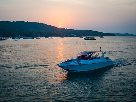 Beautiful sunset on Thailand sea with a white motor boat - background