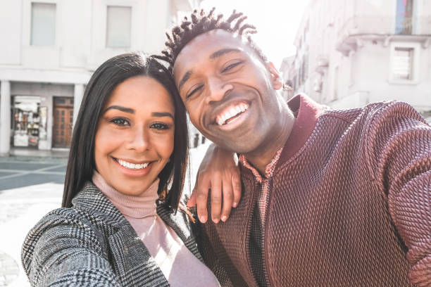 pareja latina tomando selfie foto para la historia de redes sociales-personas influyentes que se divierten con la nueva tecnología de tendencia-amor, la moda y el concepto de relación-centrarse en las caras - men latin american and hispanic ethnicity young men smiling fotografías e imágenes de stock