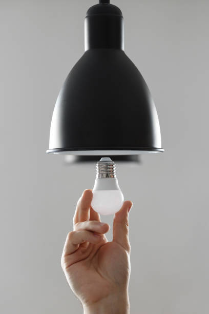 istock Changing the bulb for led bulb in floor lamp in black colour. On light gray background. 1139261611
