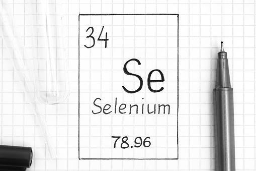 The Periodic table of elements. Handwriting chemical element Selenium Se with black pen, test tube and pipette. Close-up.