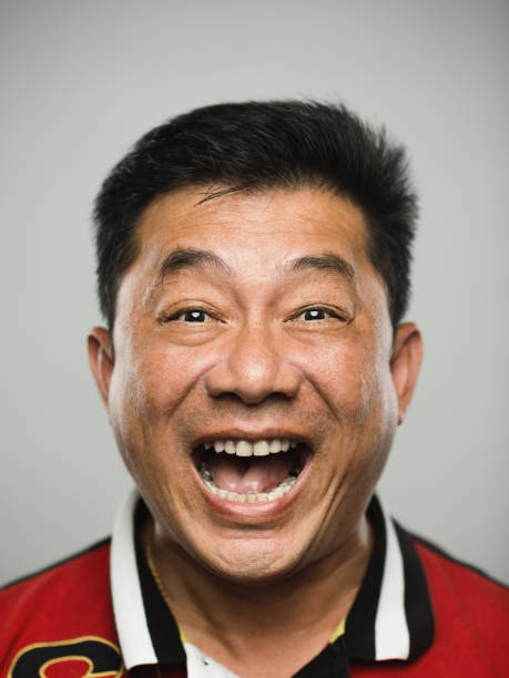 Portrait of real chinese mature man with ecstatic expression looking at camera