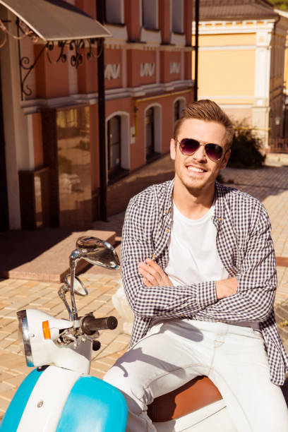 istock Handsome cute man with glasses sitting on a scooter crossing hands 1139264405