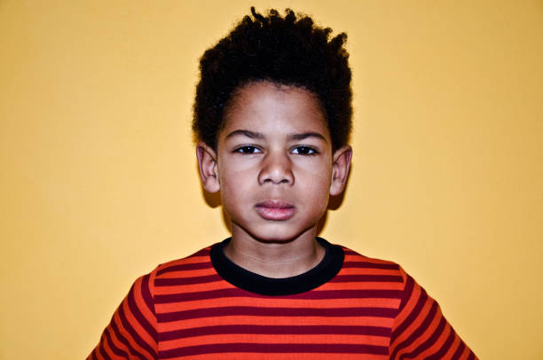 istock Serious looking little boy. Yellow background 1139265170