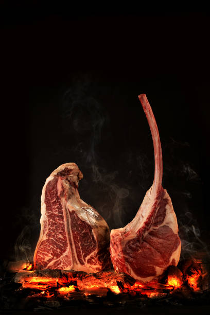 istock Whole T-Bone steak cooking on embers. Black background. 1139265309