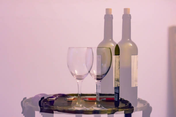 istock Double vision after alcohol consumption.Double exposure image of bottle of wine and empty glass placed on table with purse. 1139265462