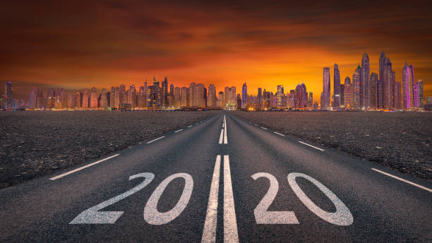 2020 new year towards the skyline at empty highway Driving on open road against the cityscape and setting sun forward to upcoming 2020 new year. Concept for success and future. town of hope stock pictures, royalty-free photos & images