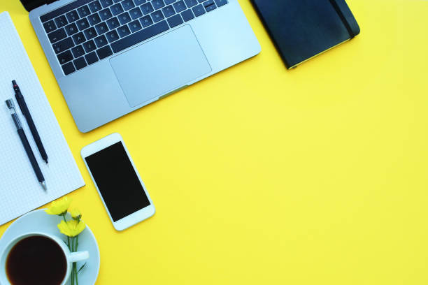 istock Business flat lay: desk with notebook, pencil, cup of coffee on yellow table. Copy space 1139269664