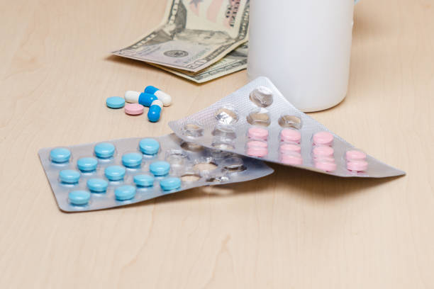 istock Blue and pink pills and dollars on the table 1139275234