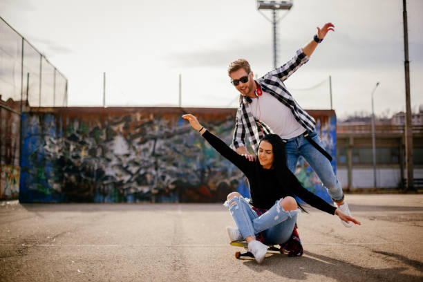 istock Young couple having fun with a skateboard 1139280543