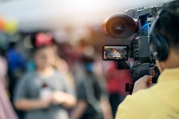istock Video camera man working outdoors with young woman reporter. 1139281521