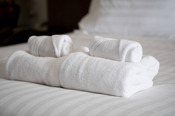 istock Stack of white bath towels on bed sheet in modern hotel bedroom interior 1139282748