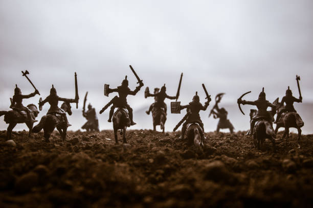 istock Medieval battle scene with cavalry and infantry. Silhouettes of figures as separate objects, fight between warriors on sunset foggy background. Selective focus 1139285880