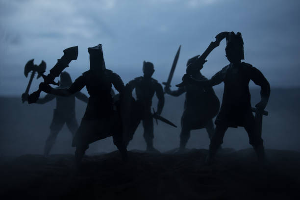 istock Medieval battle scene with cavalry and infantry. Silhouettes of figures as separate objects, fight between warriors on sunset foggy background. Artwork decoration. Selective focus 1139285935
