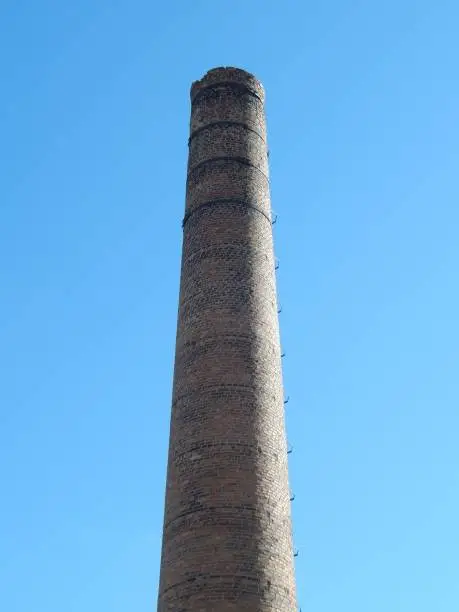Photo of Brick and tiles factory chimney built on bricks. Photo