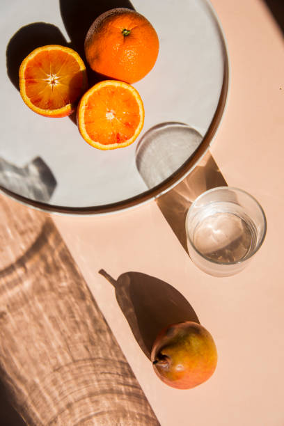 istock Pears and oranges with  art shadows on a color backround. Artistic healthy breakfast on a table. 1139294623