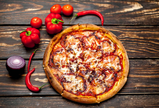 istock pizza on wooden table with ingredients, tomatoes, pepper, onion 1139299253