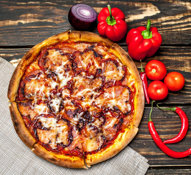istock pizza on wooden table with ingredients, tomatoes, pepper, onion 1139299393