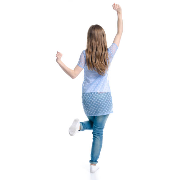 istock Woman in blue jeans standing hands up dancing happiness 1139316716