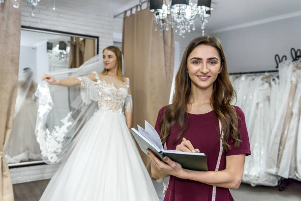 istock Designer with notepad and bride in wedding dress behind 1139317631