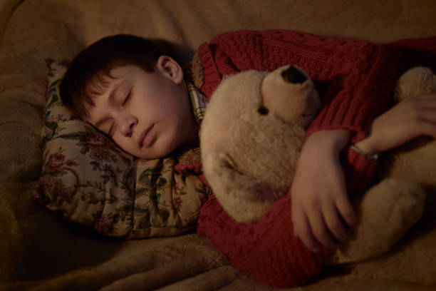 istock boy sleep in bed with bear toy 1139317823