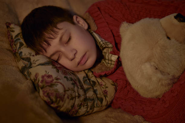 istock boy sleep in bed with bear toy 1139319590
