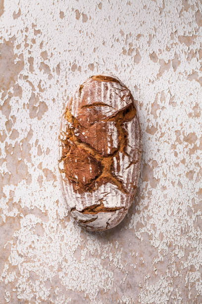 istock Whole grain bread overhead loaf on white rustic wooden table 1139323571