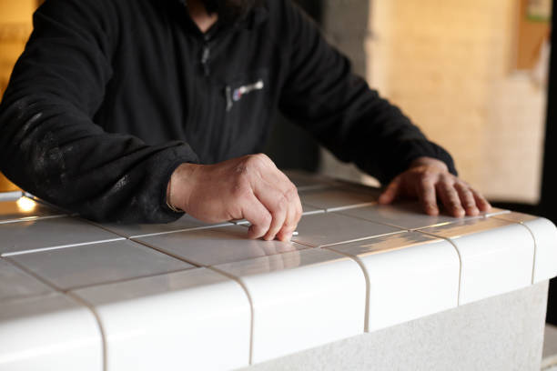 istock Man Tiling New Shop Counter With Unusual Ceramic Tile 1139324691