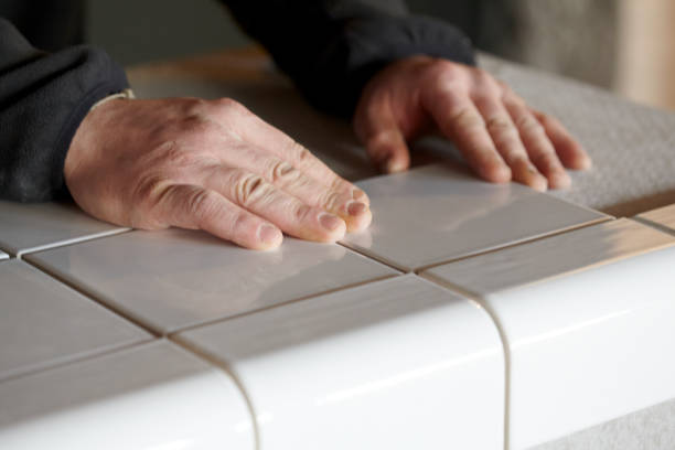 istock Man Tiling New Shop Counter With Unusual Ceramic Tile 1139326928