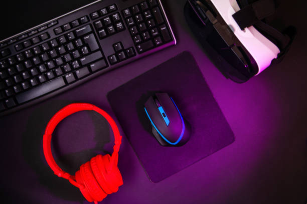 istock Top view a gaming gear, mouse, keyboard, joystick, headset, VR Headset on black table background. 1139327176