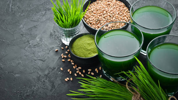 istock The juice from the green sprouted wheat, and wheat grains. On a black background. Micro Green. Healthy food. Top view. Free space for your text. 1139327849
