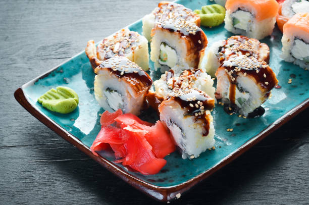 istock Sushi and rolls on the plate. Top view. Free space for your text. On a black background. 1139329075