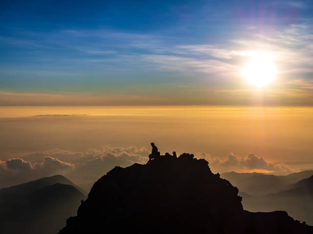 istock A Man Silhouette sitting on top of the mountain 1139329498