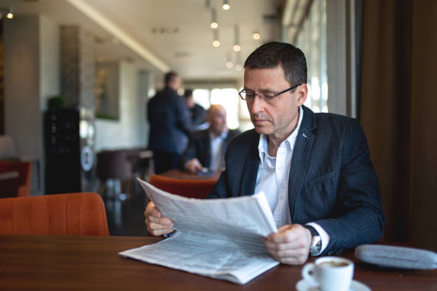 istock Senior businessman reading newspapers at a cafe 1139331827