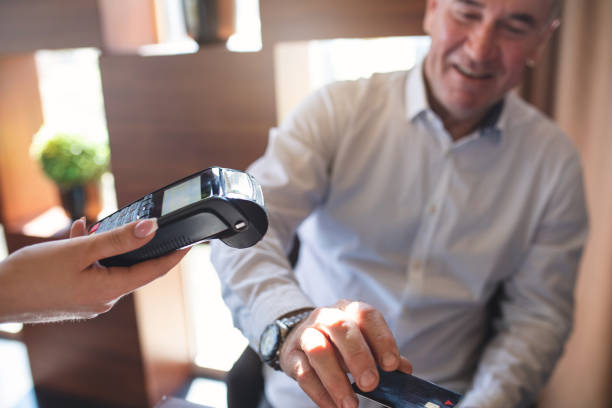 istock Smiling businessman using a credit card as a way of paying 1139332650