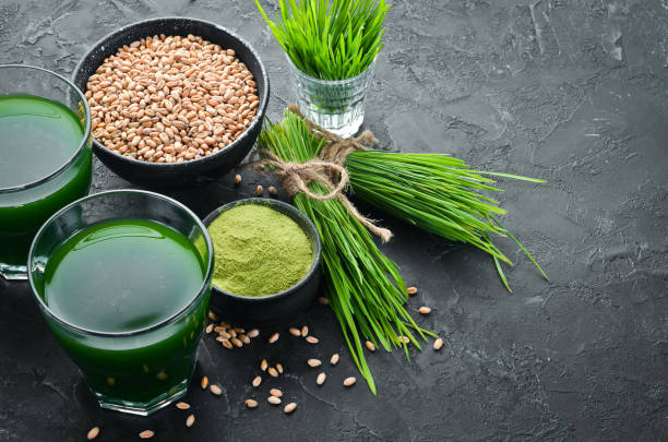 istock The juice from the green sprouted wheat, and wheat grains. On a black background. Micro Green. Healthy food. Top view. Free space for your text. 1139333737