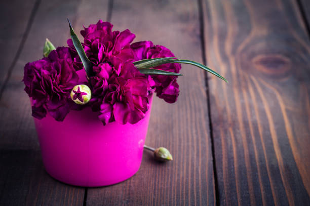 Bunch of purple carnations on rustic vintage wooden background with copy space