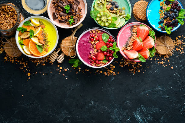 istock A great set of colored fruit smoothies with yogurt, fresh fruit and berries. A healthy breakfast. Top view. Free space for your text. On a black background. 1139341155