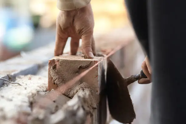 A bricklayer works on a new domestic kitchen extension using reclaimed bricks. Images show general construction and a cross section of the wall revealing insulation and outer and inner skins