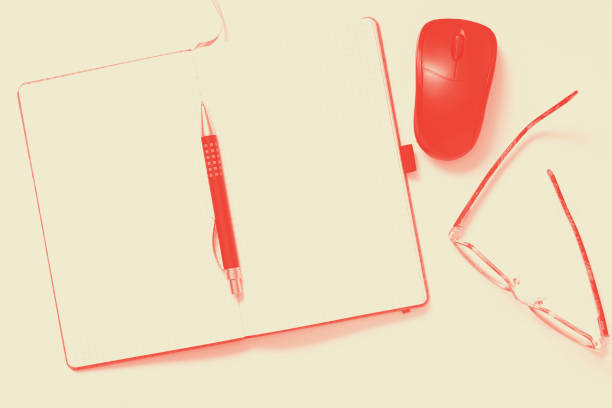 istock Office table with notebook, Pen, mouse, eyeglasses on white background. Desktop office mockup concept, Coral duotone 1139342453