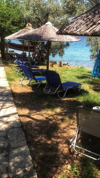 istock Blue beach beds facing towards azure sea under natural straw parasols 1139342577