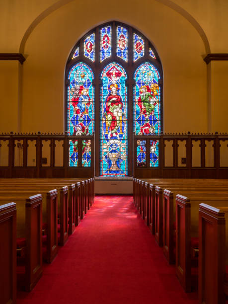 los rayos de luz de la vidriera iluminan el pasillo de la iglesia - christianity church indoors illuminated fotografías e imágenes de stock
