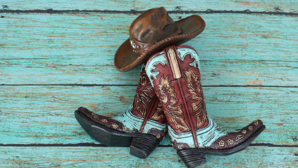 istock Cowboy boots and hat laying on teal background 1139345930