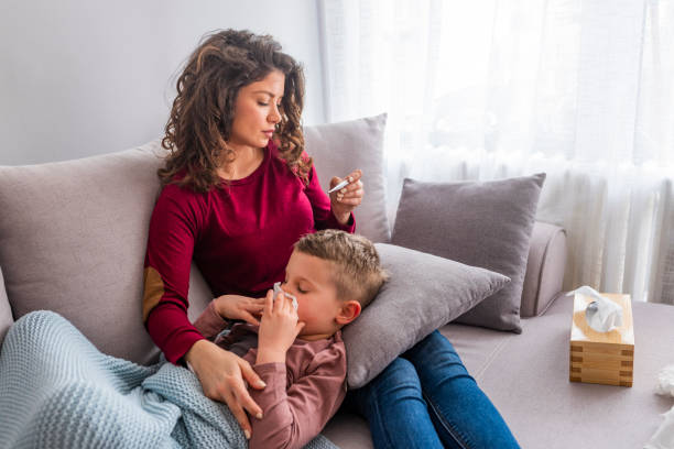 madre che controlla la temperatura di suo figlio malato. - child fever illness thermometer foto e immagini stock