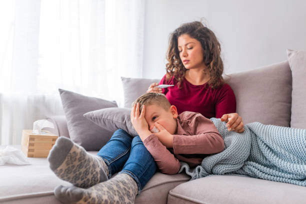 istock Mother taking care of little son suffering from cold on sofa. 1139351991