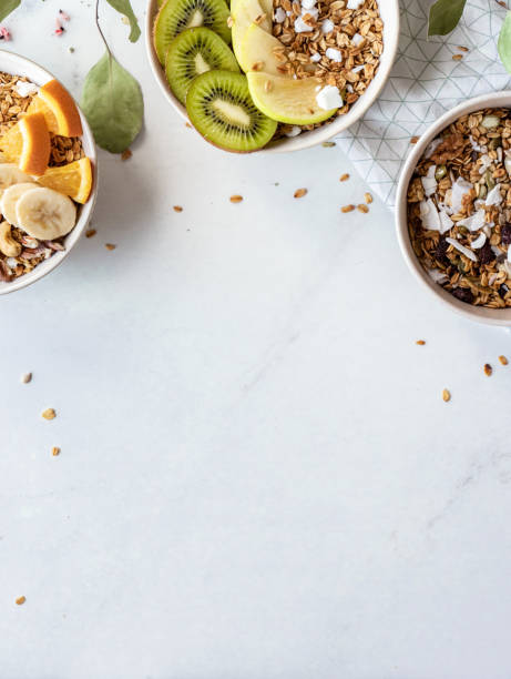 健康的な朝食のコンセプト、穀物のグラノーラ食品、フルーツ、ボウルオーガニックミューズリーの朝の食事のオートテーブル、健康栄養のためのビーガンの背景とデトックススナック垂直� - oatmeal porridge dried fruit bowl ストックフォトと画像