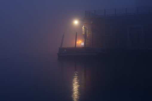 Night view canal on Murano island in the fog with illumination. Venice, Italy.
