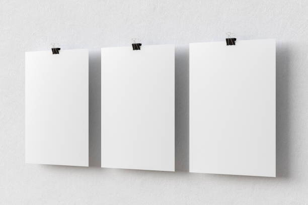 Three blank paper posters hanging on binder clips on white wall background. 3d illustration
