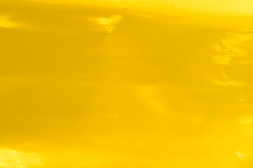 Shiny hot yellow gold foil golden color glitter decorative texture paper: Bright brilliant festive metallic textured empty wallpaper backdrop: Tin metal material for holiday craft design decoration