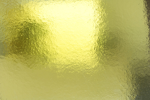 Shiny hot yellow gold foil golden color glitter decorative texture paper: Bright brilliant festive metallic textured empty wallpaper backdrop: Tin metal material for holiday craft design decoration